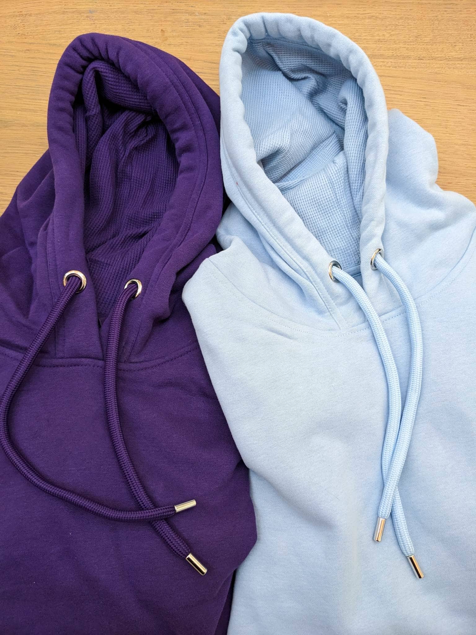 Close up of luxe organic hoodies in light blue and purple